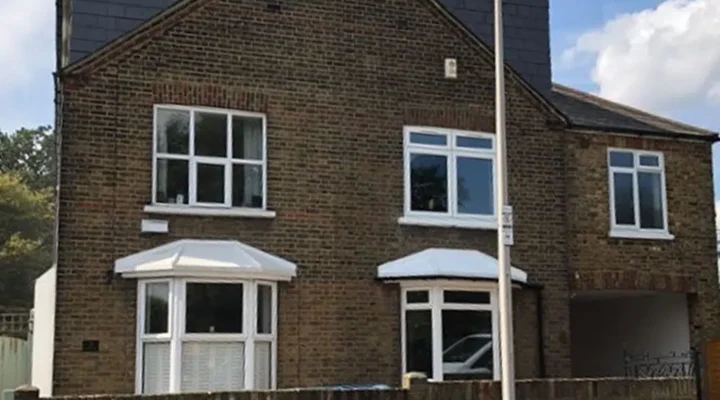 Traditional brick house with white windows and doors.