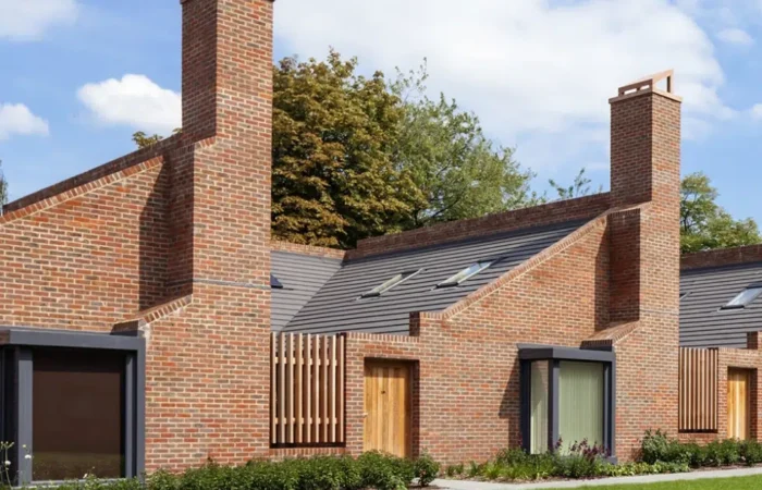 Modern brick houses with distinctive chimneys and skylights.