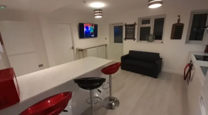 Modern kitchen with bar stools and sofa