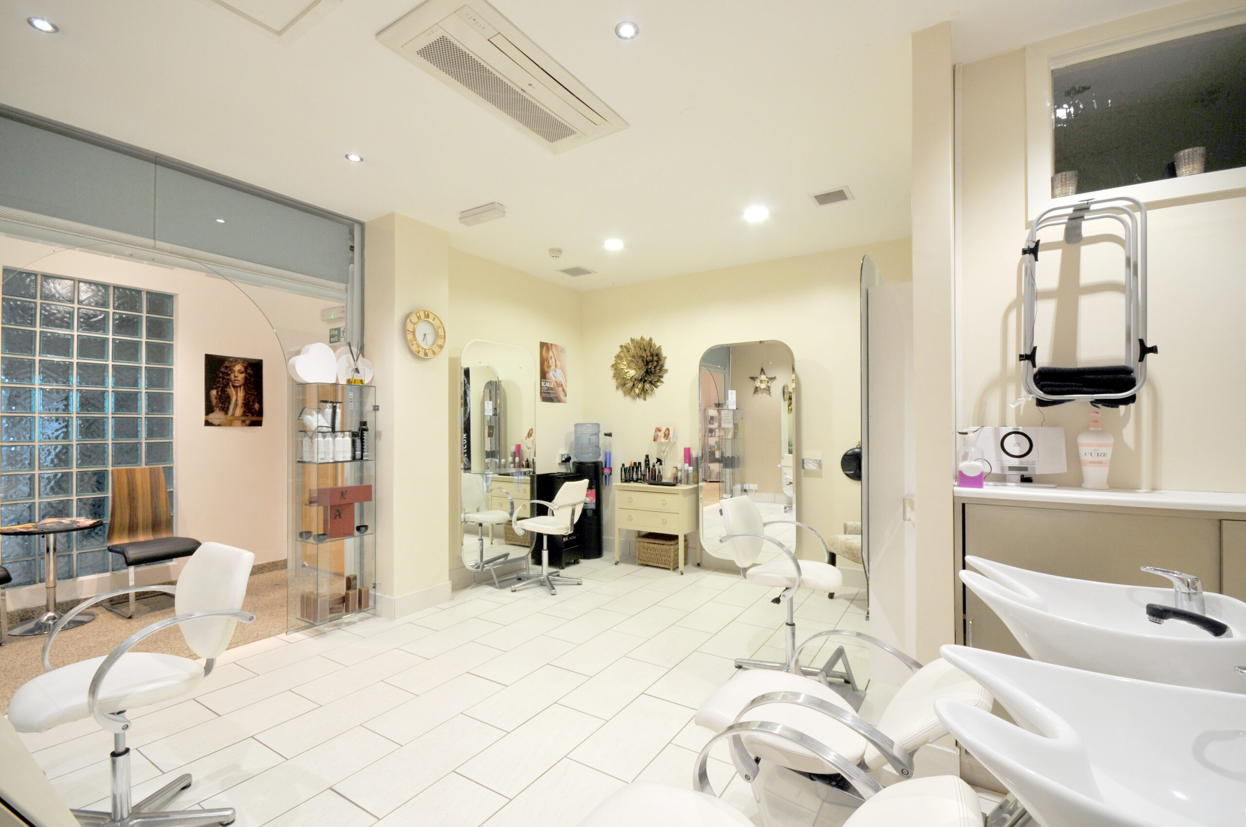 Modern hair salon interior with white chairs.