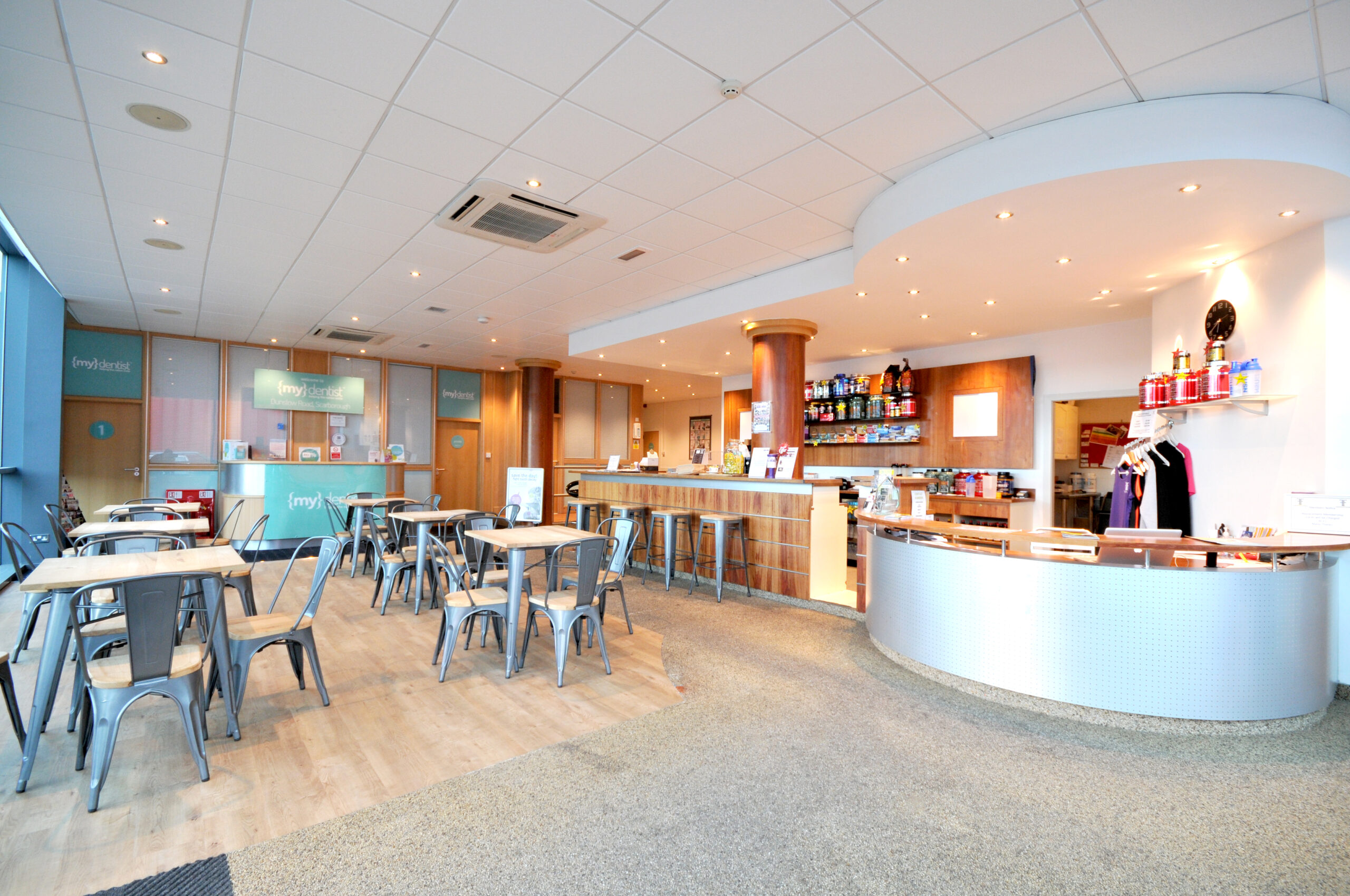 Spacious modern dental clinic reception area with seating.