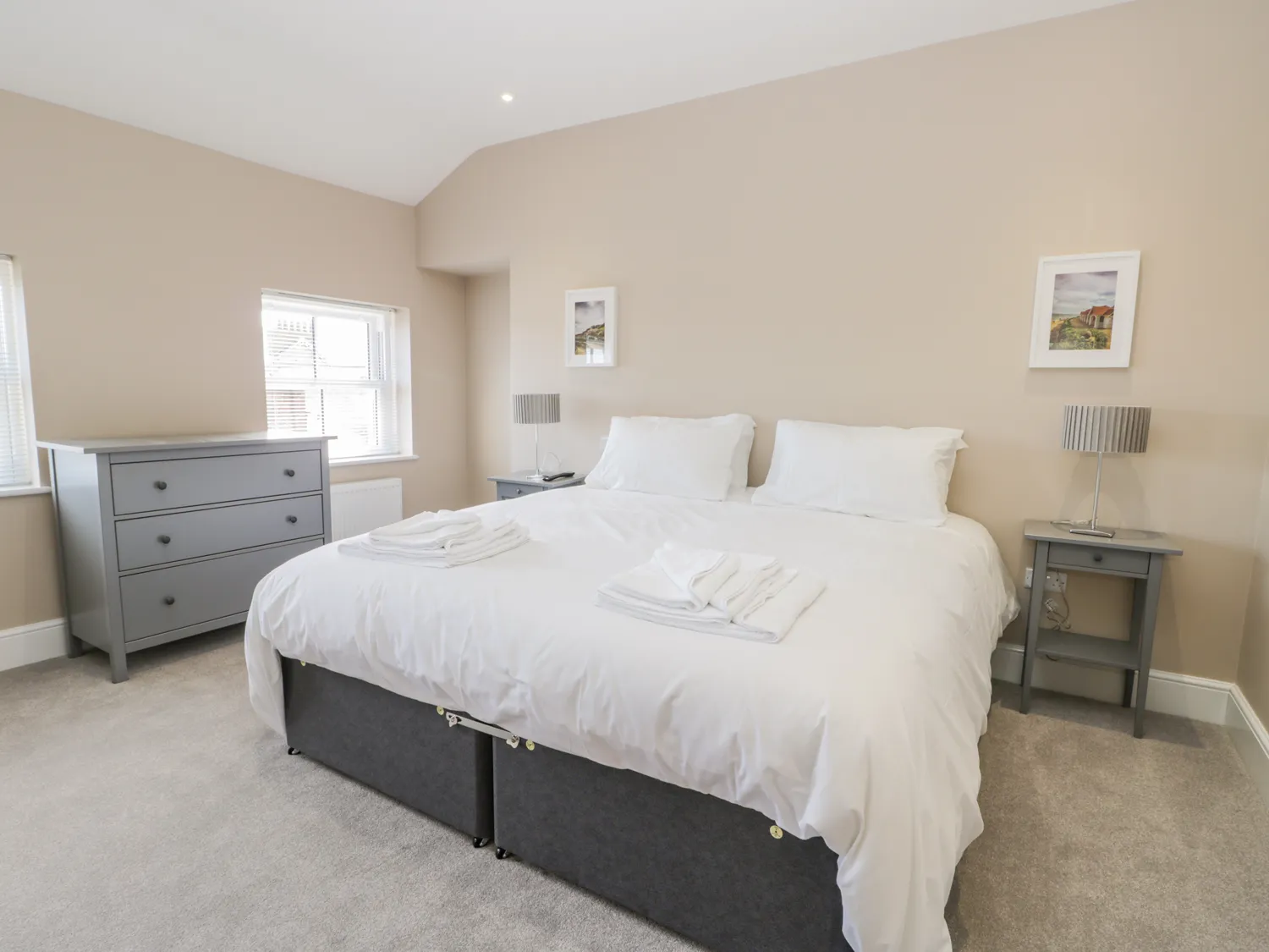 Cosy bedroom with king-size bed and grey furniture.