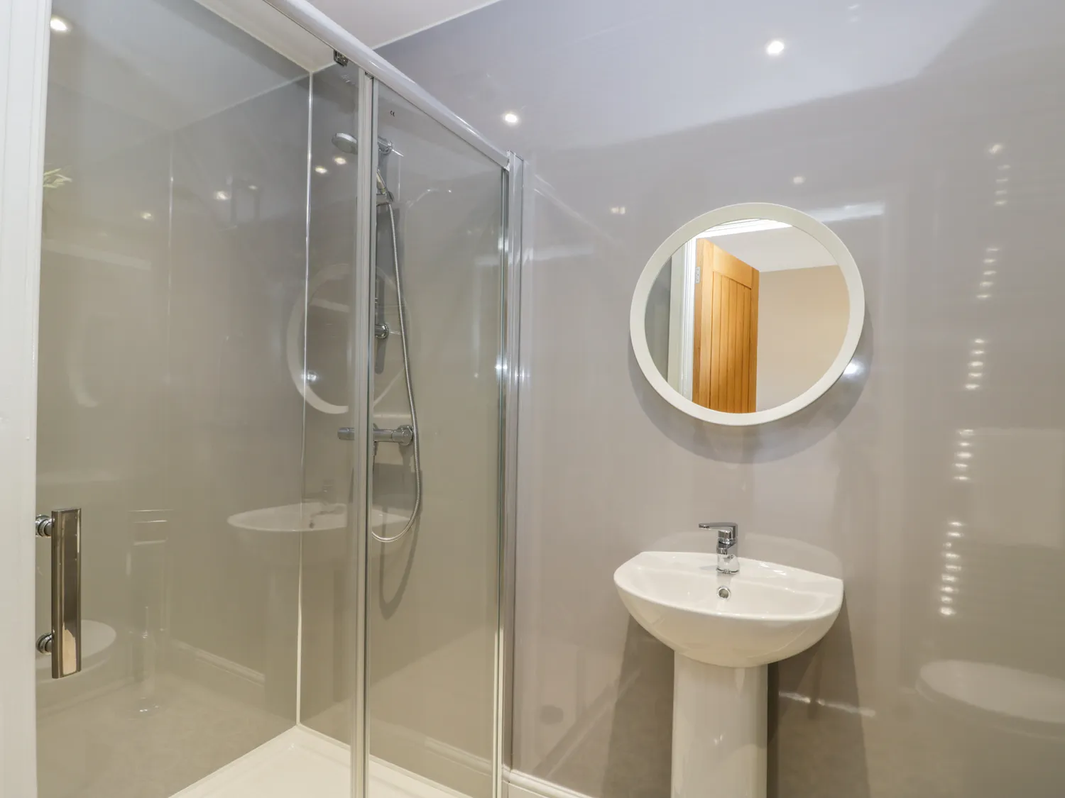Modern bathroom with shower and circular mirror