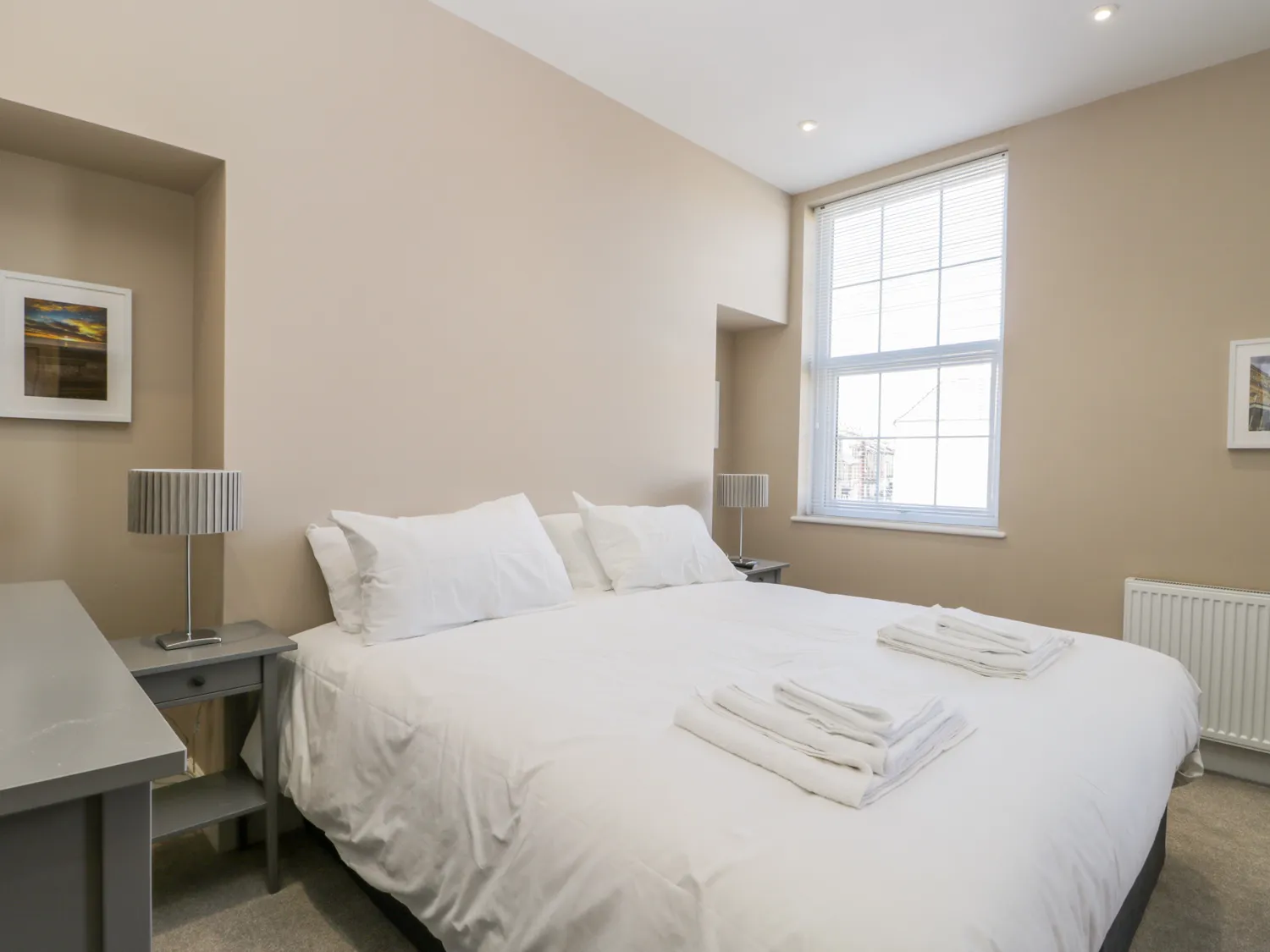 Bright bedroom with double bed, modern decor.