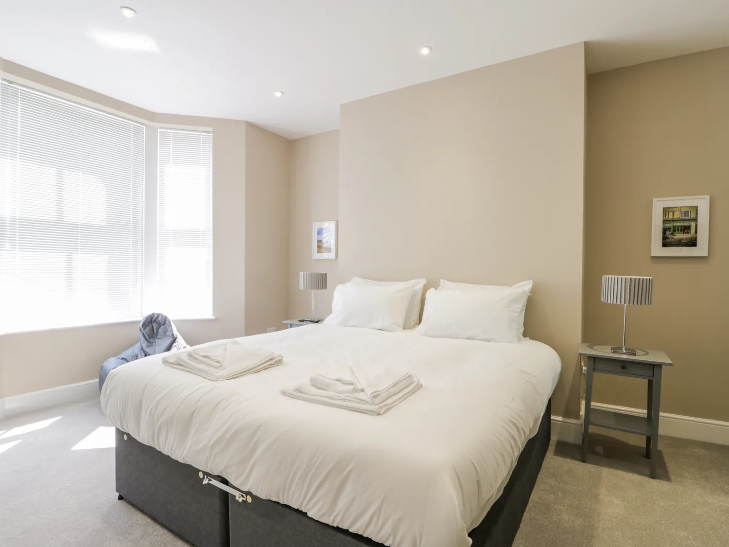 Bright modern bedroom with double bed and decor.