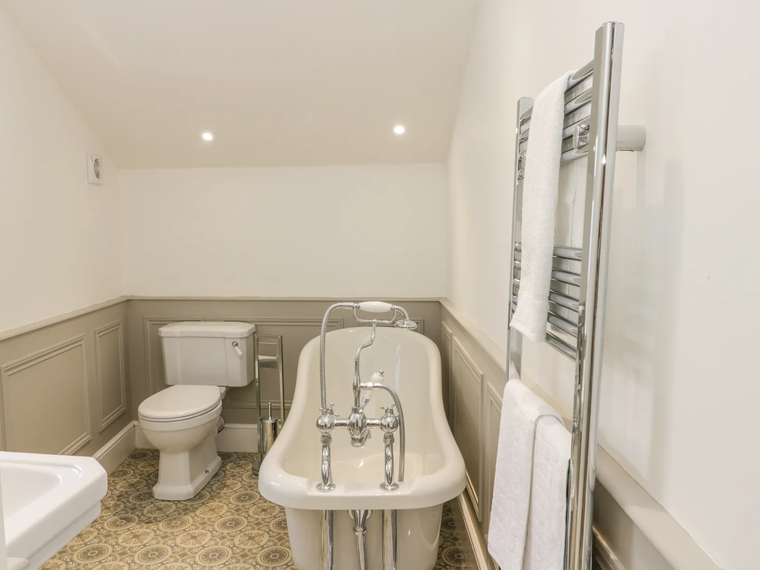 Bathroom with bathtub, toilet, towel rail