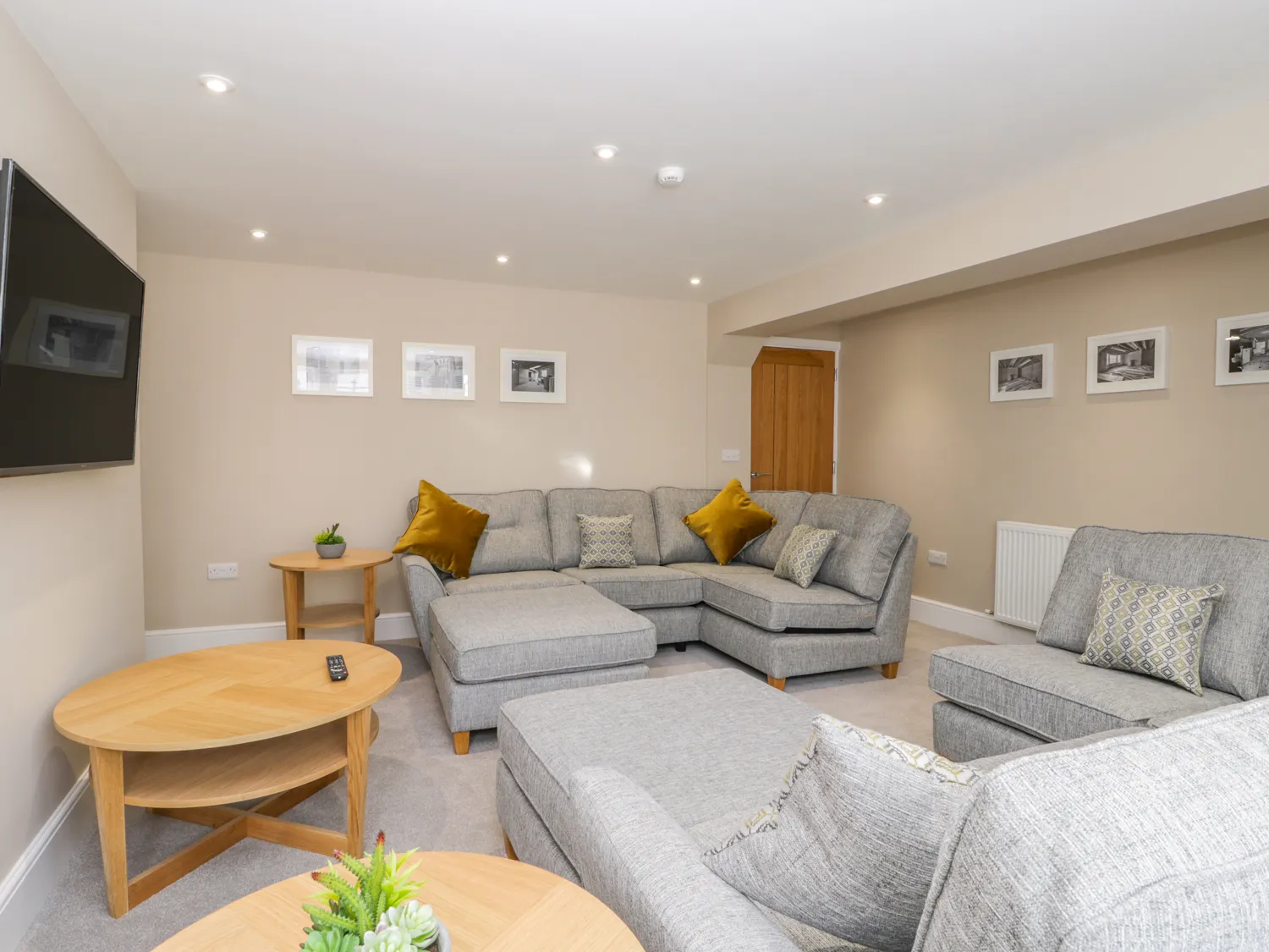 Modern lounge with grey sofas and wooden tables.