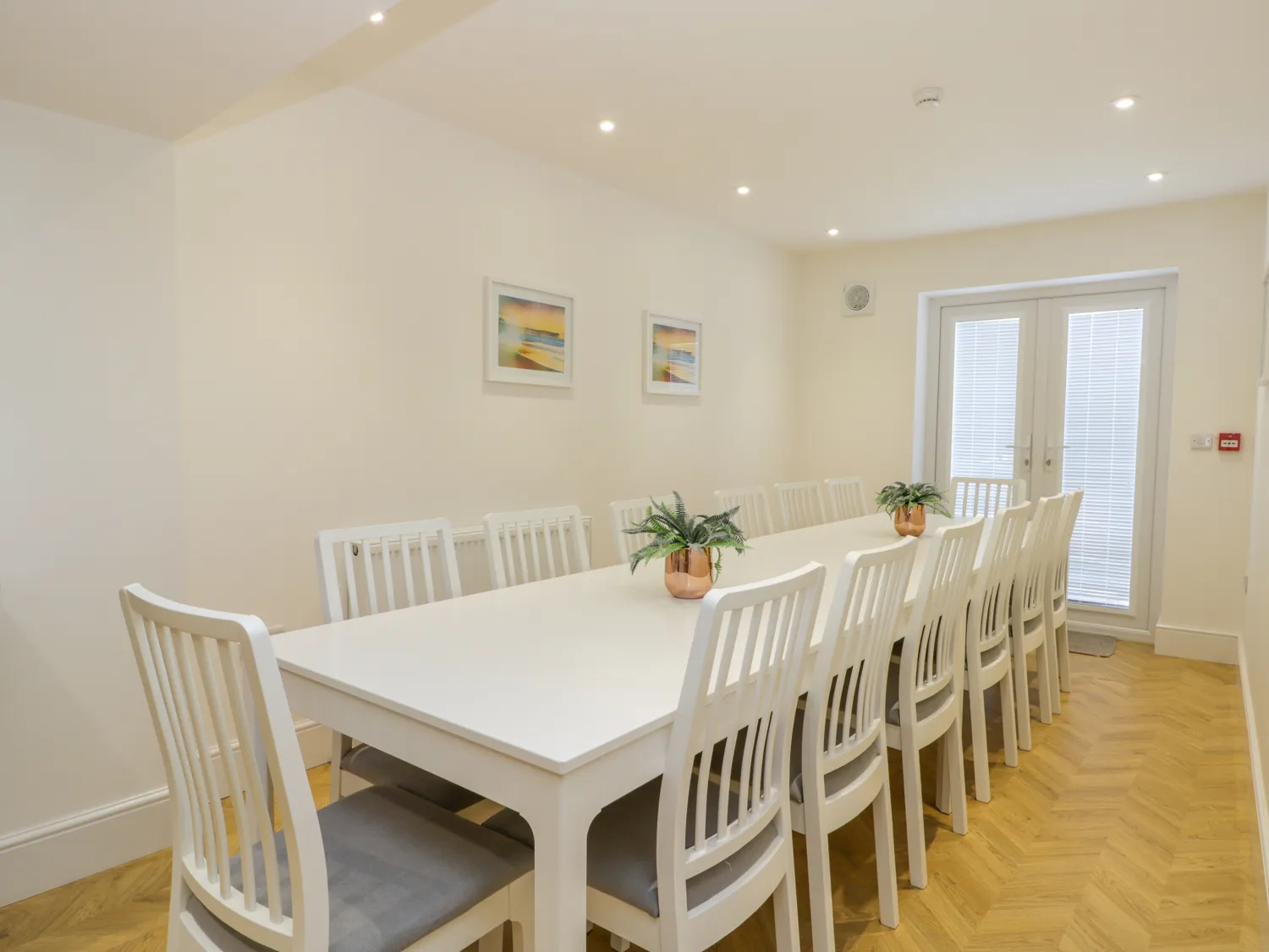 Spacious dining room with white table and chairs.