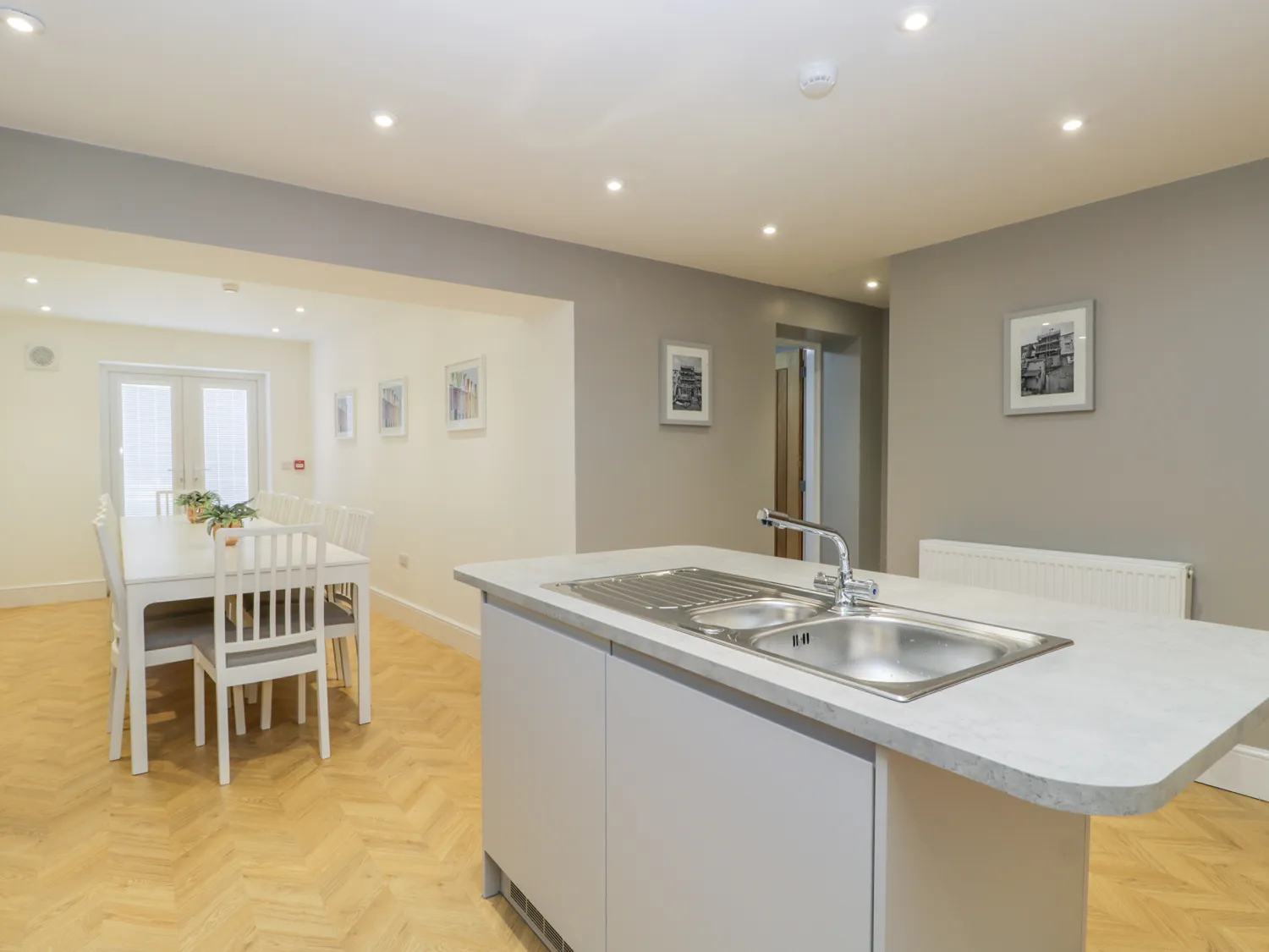 Modern kitchen and dining area with white furniture.
