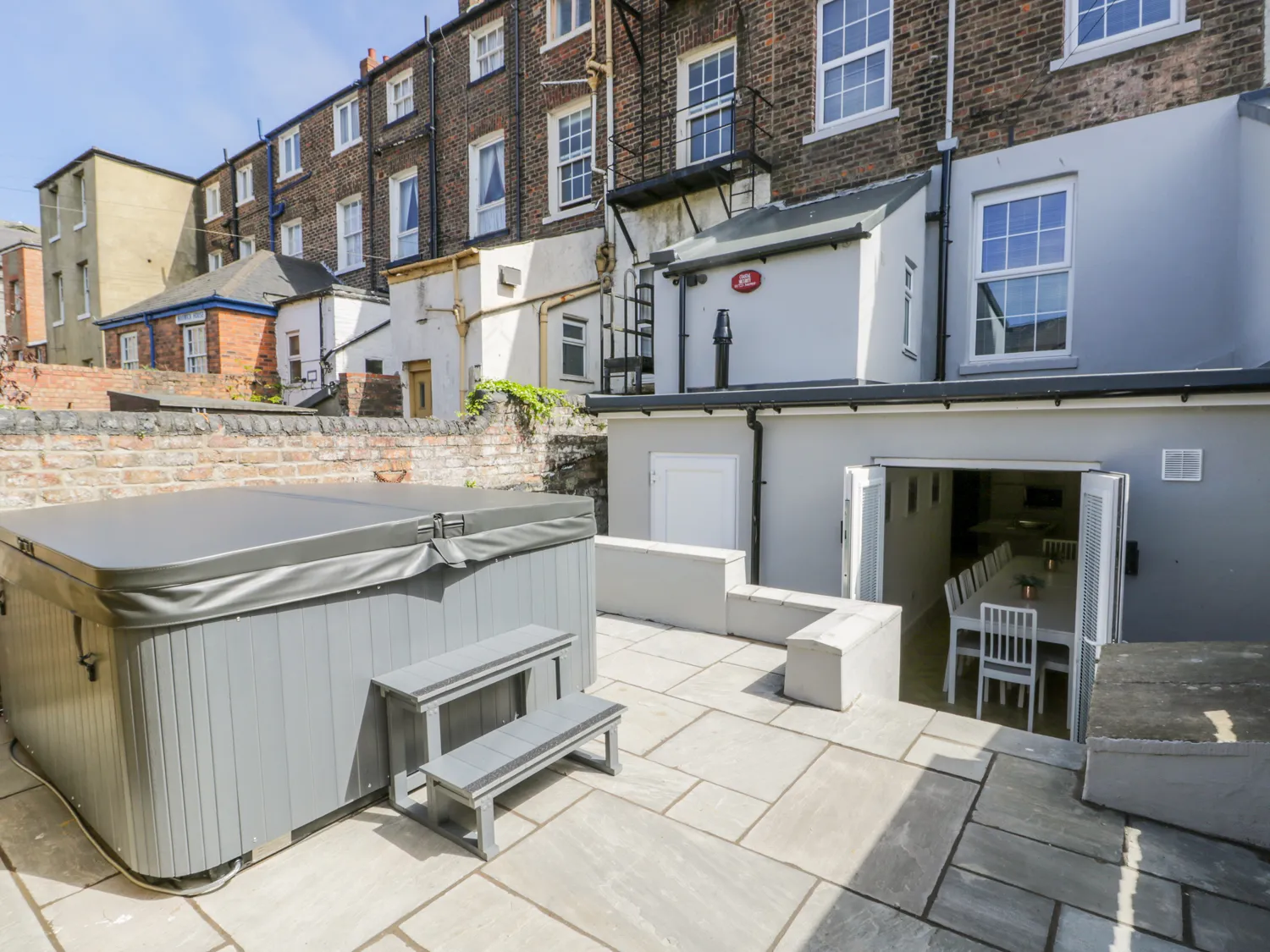 Backyard with hot tub and patio seating area.