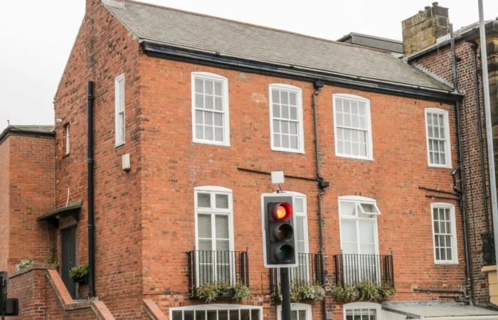 Red brick building with traffic light on red.