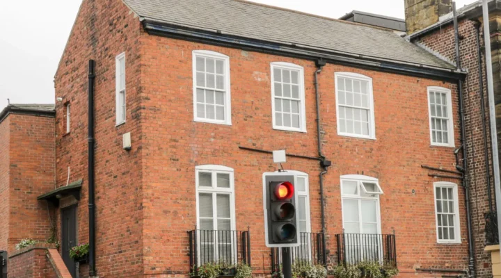 Red brick building with traffic light on red.